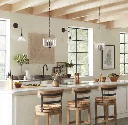 A comfortable, modern kitchen illuminated by pendants and wall lighting.