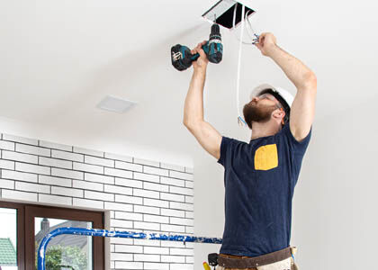 Electrician reinstalling low-quality fixture highlighting wasted labor