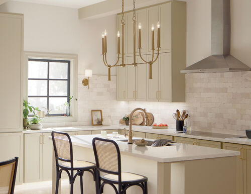  A  kitchen space with a chandelier, wall sconce, and undercabinet lighting providing a coordinated, intentional approach to illumination.