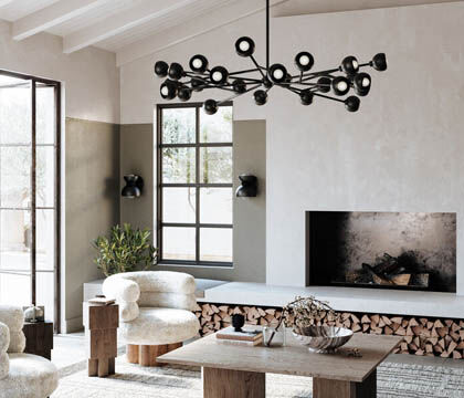 A chandelier and sconces in a soft black finish add depth and contrast to a neutral-tone living room.