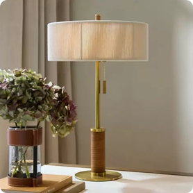 A desk illuminated by a cozy table lamp