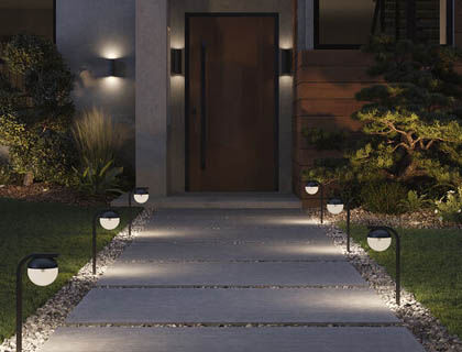 An outdoor area is effectively lit by path lights and durable sconces.
