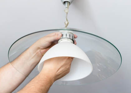 Contractor handling broken light fixture representing replacement costs