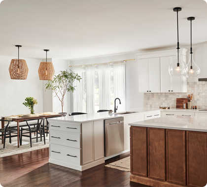 An open kitchen-dining space benefits from visually distinct overhead lighting to establish different zones.