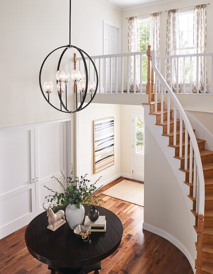 Dramatic chandelier lighting in a two-story foyer entryway.