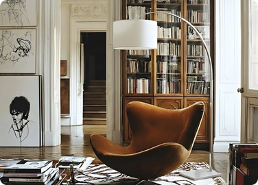 A floor lamp illuminates a cozy seating space for in a modern study area.