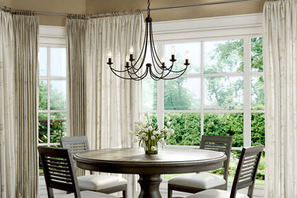 A well-sized chandelier above a dining room table.