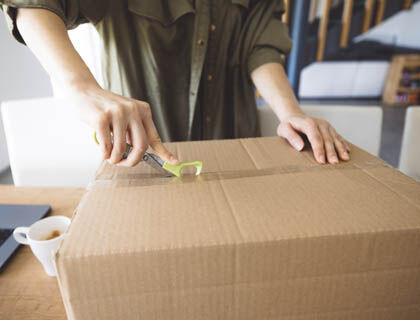 Designer inspecting lighting delivery for accuracy and damage upon arrival.