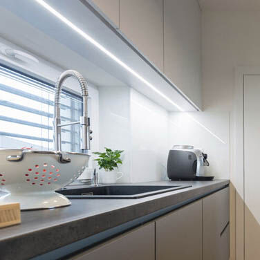 Sleek task lighting under a cabinet provided by LED tape lights.